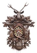 A large carved Black Forest cuckoo wall clock: the eight-day duration weight-driven movement