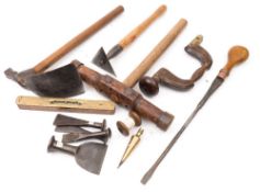 A collection of shipwright's tools:, including a caulking mallet, an adze,