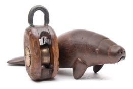 A carved wood figure of a manatee: indistinctly inscribed to the base, 19cm long,