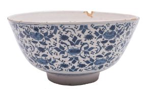 A large English blue and white delftware bowl: the exterior painted with stylised floral sprays and