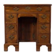 A George III mahogany kneehole desk:, the top with a moulded edge and rounded corners,