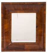An 18th Century walnut cushion frame wall mirror:, with later inset rectangular bevelled plate,