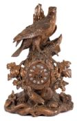 A large 19th century carved Black Forest lindenwood mantel clock in the form of a bird of prey: the