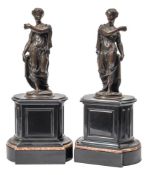 A pair of 19th century bronze classical female figures: draped in robes raised on black marble