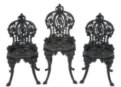 A suite of five Coalbrookdale type cast iron garden chairs:, three with lower backs,