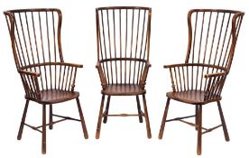 A set of three ash, fruitwood and beech stick back Windsor wing armchairs:, with curved backs,