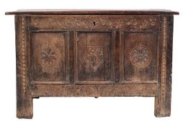 A 17th century carved oak rectangular coffer: with a plain hinged top,