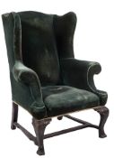 A carved and ebonised wing frame armchair in the George III taste:,