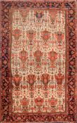A Kashgai rug: the beige field with a repeated design of urns of flowers and foliage and with bird
