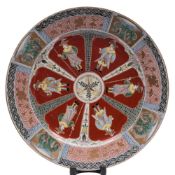 A Japanese Imari 'Dutch Merchant' charger: the cavetto painted with six iron-red ground lappet