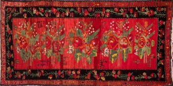 A Turkish rug:, the rose pink field with a row of floral and leaf medallions,
