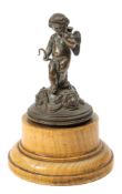 A 19th century bronze study of Cupid: on a domed base with female mask decoration,
