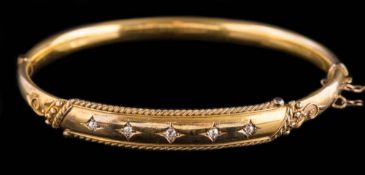 A late 19th century 15ct gold and diamond hinged bangle: with five square-set round old