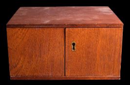 A small mahogany coin cabinet,: the double doors enclosing eight trays,