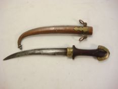 A Tuareg dagger: of traditional form with wooden grip and silver plate mounted copper scabbard.