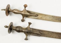Two steel handled tulwars:, of traditional form, blade length 69cm and 67cm.