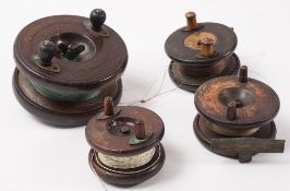A group of four mahogany and brass star backed reels:, unsigned , various sizes and condition..