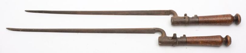 Two 1853 pattern socket bayonets on later wooden grips:, 64cm long.