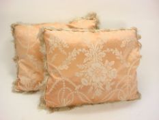A pair of cream and pink silk cushions:, with floral pattern and tassel fringe,