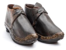 A pair of late 19th century child's clogs:, the leather upper with pressed brass buckle and toe cap,