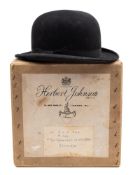 A black felt bowler hat by Austin Reed:, in an associated Herbert Johnson hat box, 60cm diameter.