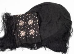 A black silk monochrome floral embroidered shawl with tassel fringe,