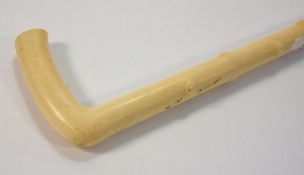A late 19th/early 20th century ivory walking cane:, in the style of a tree root with plain handle,