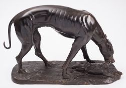 A reproduction bronzed model of a hound with hare:, on a naturalistic base. 39 cm high..
