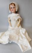 A Schoenau and Hoffmeister bisque head doll, impressed S. PB within a star. H 1900.5.