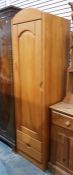 Modern pine single wardrobe, the arched panel door enclosing hanging space, with two short drawers