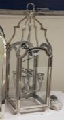 Four-branch hanging lantern within a glazed steel frame, height 85cm (VAT payable on hammer)