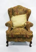 Wing-back armchair in yellow patterned upholstery to cabriole front legs