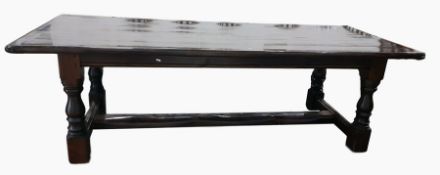 Stained pine plank top dining table with fluted end supports, raised upon turned legs to block