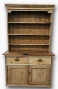 Pine dresser of three shelves above base of two drawers and two doors, 133.5cm