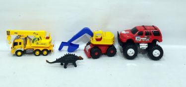 Box of plastic toys to include a red monster truck, a Evoplocephaius, a yellow crane and a yellow