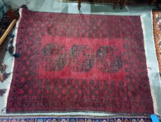 Red ground Eastern style floor rug with three central medallions, 152cm x 116cm