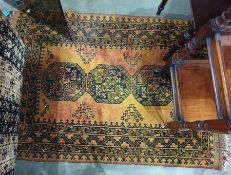 Mustard ground Eastern floor rug with three central medallions decorated in black, 133cm x 102cm