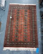 Brown ground Eastern floor rug with two rows of 12 elephant foot guls to the central field and