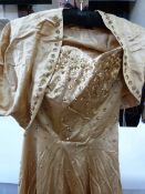 1950's evening wear including a gold-coloured satin strapless gown decorated with sequins and a