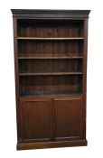 Old oak open bookcase with straight moulded cornice, adjustable shelves, cupboard below enclosing