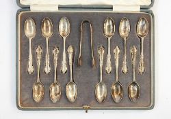 Set of 12 George V silver teaspoons, shaped thread borders, London 1922 and the matching sugar nips,