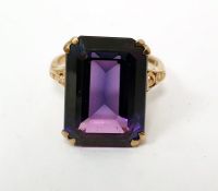 9ct gold dress ring set with an emerald-cut synthetic corundum, with pierced collet and shoulders,