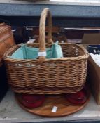 Wicker picnic basket with some ceramic plates and napkins, other baskets and a lazy susan with red