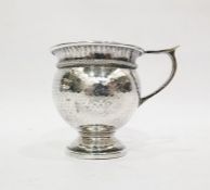Arts & Crafts silver mug by A E Jones, Birmingham 1925, of bulbous hammered form with wire twist