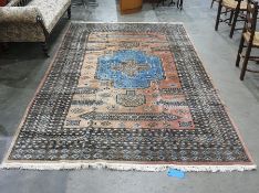 Salmon ground rug with stepped fawn and sky blue central medallion, assorted floral motifs to a