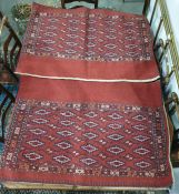 Pair of red ground camel saddle bags decorated with five hooked medallions to the red ground