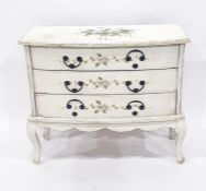 Painted bowfront chest of three drawers, floral sprays upon the cream ground, to shaped apron and