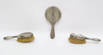 Three piece silver-backed dressing table set with engine-turned decoration and monogram,