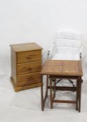 A 20th century pine bedside chest of three drawers, a nest of coffee tables and an office chair (3)