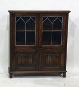 A 20th century oak cabinet with leaded glazed doors above two linen-fold doors, 85cm x 107.5cm